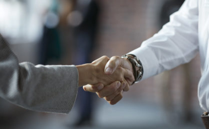 Businesspeople making handshake at conference